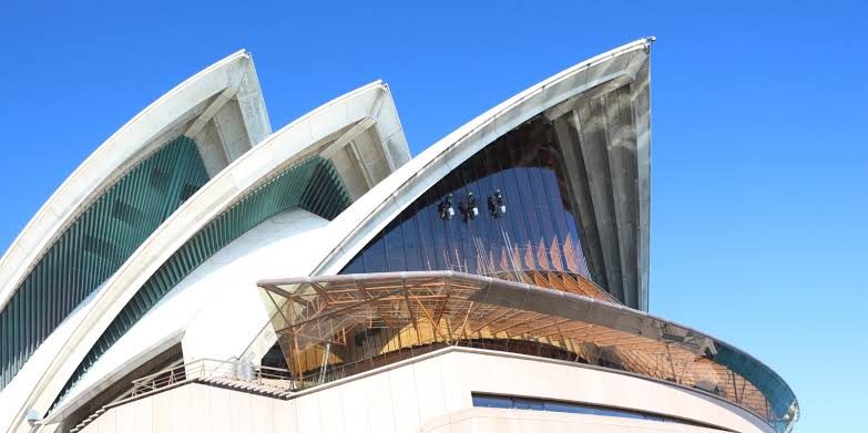 Up Down Access technicians on ropes on the glass of the Sydney Opera House